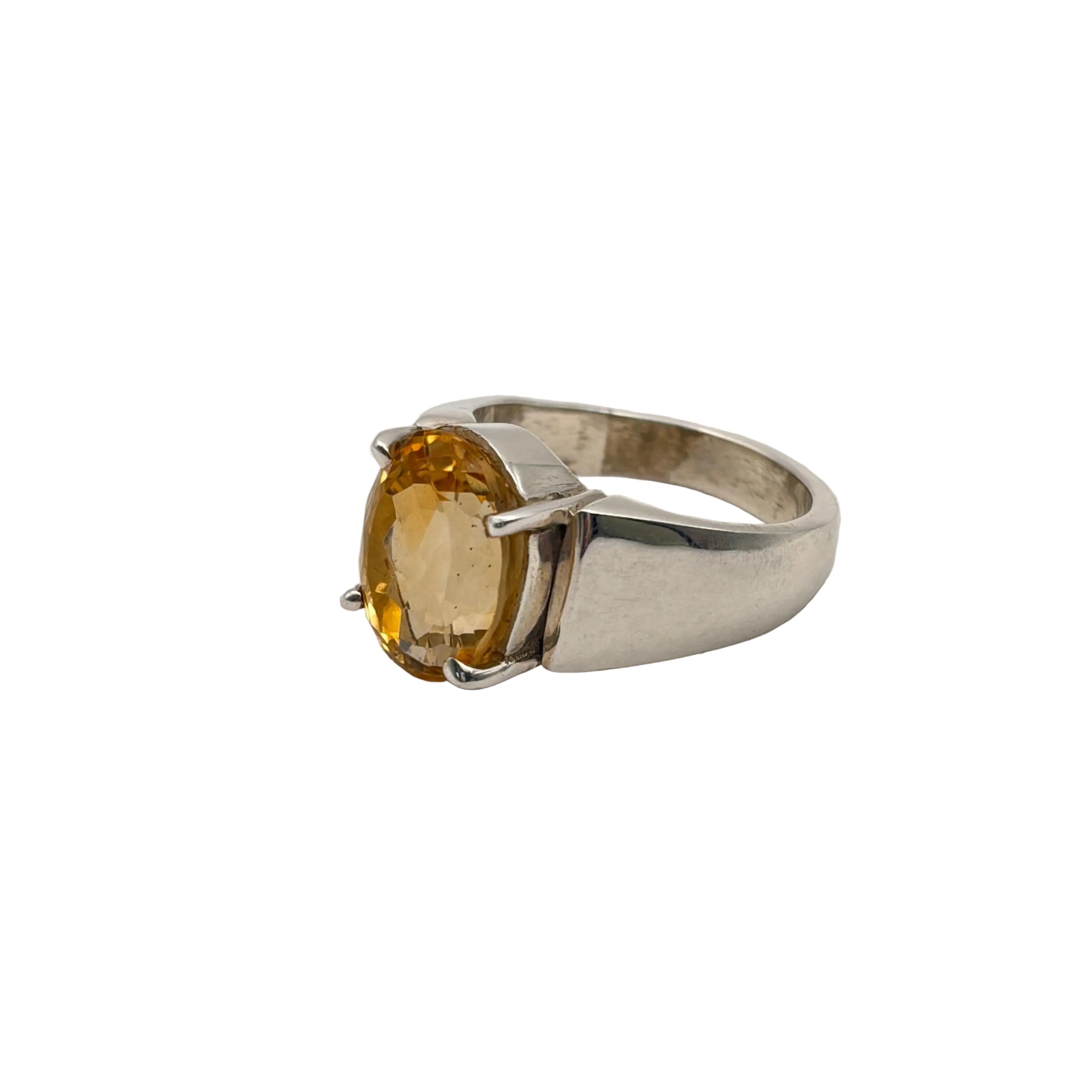 Silver ring with a yellow citrine gemstone on a light gray background